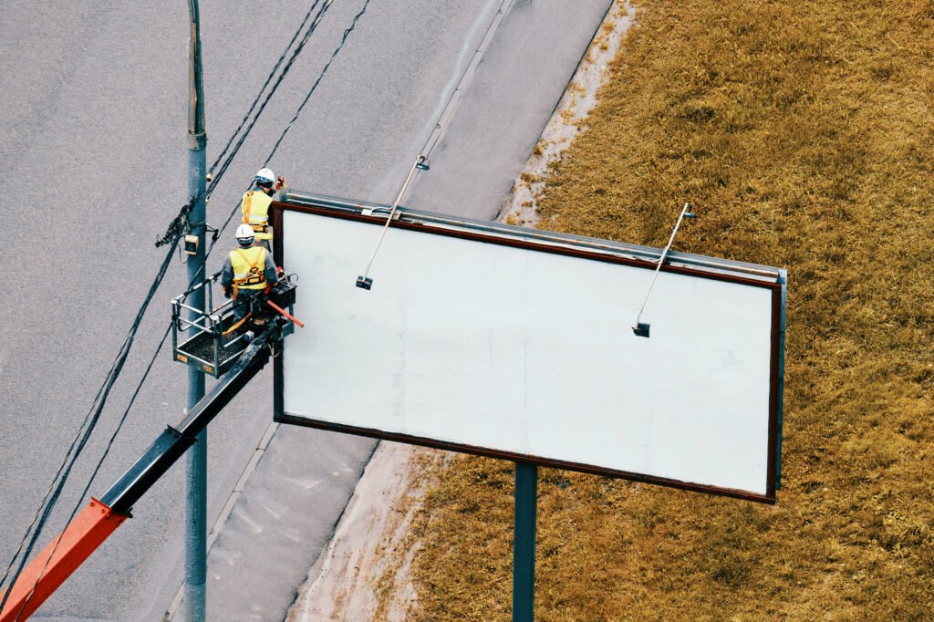 workers hang a roadside poster on a billboard near 2026 01 11 09 37 19 utc